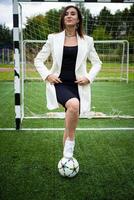 portrait of a beautiful woman football player in a strict office suit. photo