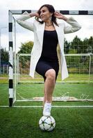 retrato de un hermosa mujer fútbol americano jugador en un estricto oficina traje. foto