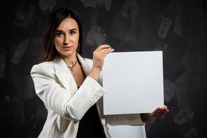 A business woman holds an empty sign in front of the camera. photo