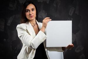 A business woman holds an empty sign in front of the camera. photo