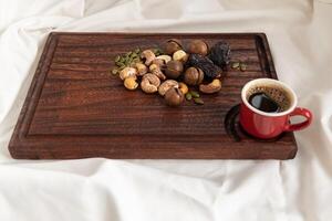 A tasty charcuterie board full of various nuts and coffee for breakfast. photo