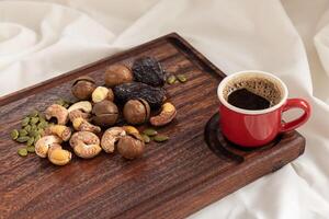 un sabroso charcutería tablero lleno de varios nueces y café para desayuno. foto