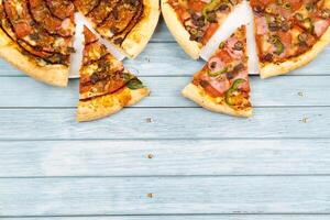 dos diferente delicioso grande pizzas en un azul de madera antecedentes foto