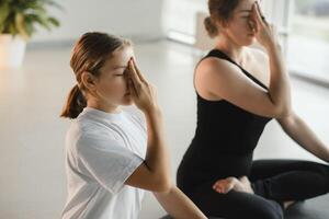 Mom and teenage daughter do gymnastics together in the fitness room. A woman and a girl train in the gym photo