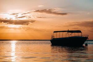 barco a puesta de sol en el indio Oceano apagado el costa de Mauricio foto