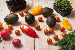 Assorted vegetables lying on a wooden table photo