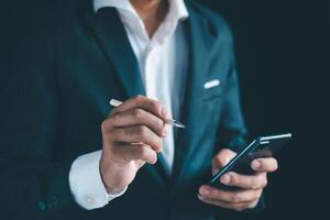 Businessman's hands working using a mobile phone photo