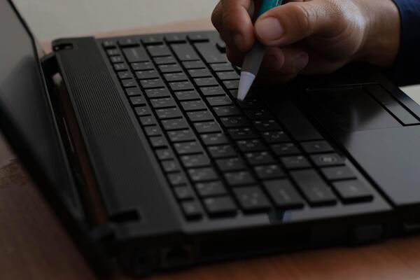 Man working at home, hand holding pen, contemplating planning, working with laptop computer, work concept