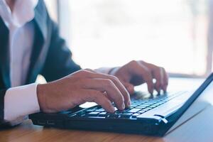 Businessman or accountant working on laptop computer with business documents on office table photo