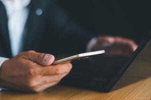 Businessman's hands working using a mobile phone photo