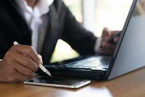 Businessmen or accountants work on computers and write down business documents on their desks. photo