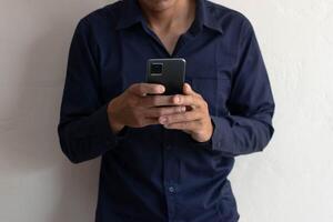 Man playing mobile phone in house, typing messages, chatting online, surfing the internet. photo