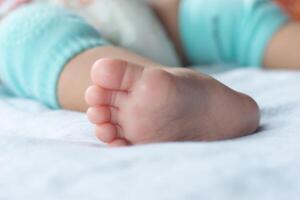 Close-up of the baby's soft feet on the mattress photo