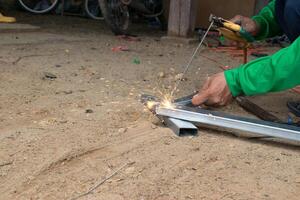 An industrial worker who welds steel with a lot of sparks in a factory. photo