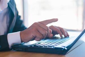 Businessmen or accountants work on laptops with business documents on their desks photo