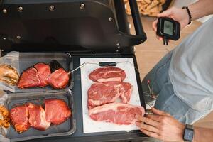 Preparation for Cooking meat on an open grill with temperature check photo