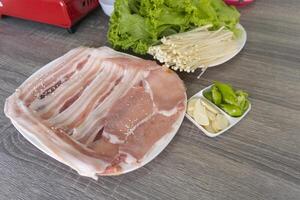 Fresh raw pork belly on the white plate for Samgyeopsal or Korean BBQ. photo