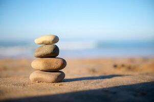 Still life with stacked pebbles, stones on the sandy beach against the background of Atlantic ocean with breaking waves photo