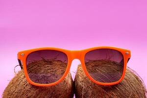 dos todo cocos y naranja lentes en un rosado antecedentes. foto