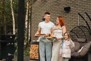A happy family has prepared lunch and will eat at their house. Portrait of a family with food in their hands photo