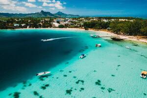 Aerial photography of the East coast of the island of Mauritius. the blue lagoon of the island of Mauritius is shot through from above. The boat is floating on a turquoise lagoon photo