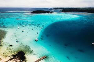 Aerial photography of the East coast of the island of Mauritius. the blue lagoon of the island of Mauritius is shot through from above. The boat is floating on a turquoise lagoon photo