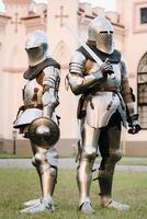 Two knights in armor on the background of a medieval castle.A medieval concept.Metallic texture photo