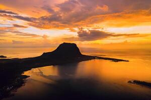 Aerial view with ocean at warm sunset time and Le Morn mountain in Mauritius. photo