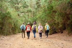 Group of women having fun walking in the woods - Adventure and travel people concept photo
