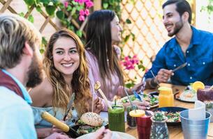 contento amigos almorzando con sano comida en bar café desayuno tardío - joven personas teniendo divertido comiendo comida y Bebiendo Fresco batidos en restaurante - salud nutrición estilo de vida concepto foto