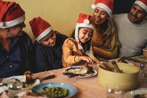 Happy Latin family dining together while celebrating Christmas holidays at home photo