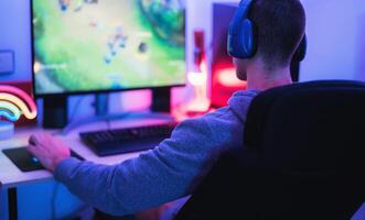 Young gamer playing online video games while streaming on social media - Youth people addicted to new technology game photo