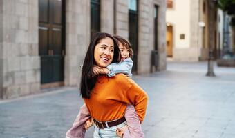 contento Sureste asiático madre con su hija teniendo divertido en el ciudad centrar - encantador familia al aire libre foto