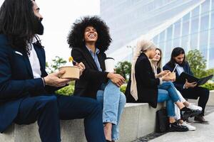 multirracial negocio personas tomando un descanso y comiendo un comida fuera de el oficina foto