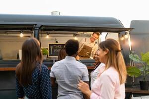 contento multirracial personas comprando comida desde comida camión cocina foto