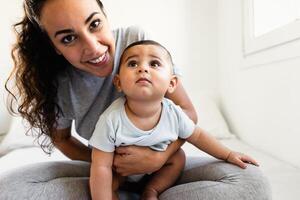 Happy mother having fun with her little baby on bed - Family and Maternity concept photo