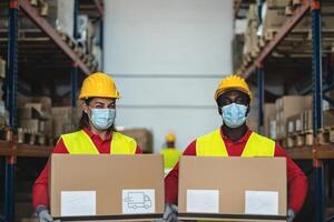 equipo trabajando en almacén cargando entrega cajas mientras vistiendo cara quirúrgico máscara durante corona virus pandemia - logístico y industria concepto foto