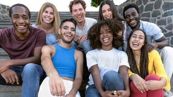 Happy multiracial group of diverse friends hang out in the city - Young people lifestyle concept photo