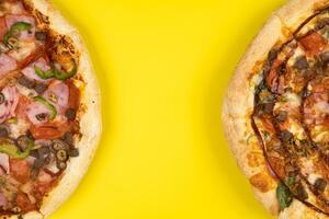 dos diferente delicioso grande pizzas en un amarillo antecedentes foto