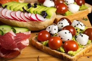 Assorted sandwiches with fish, cheese, meat and vegetables lying on the board photo