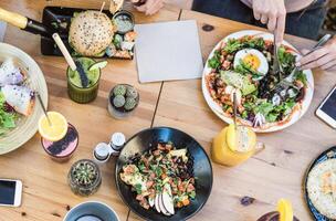 Top view of young friends eating healthy lunch in bar restaurant photo