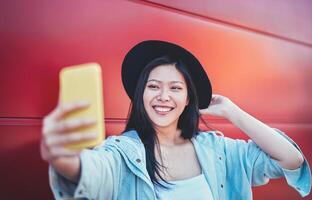 contento asiático niña haciendo un vídeo historia con móvil inteligente teléfono al aire libre - chino mujer web influencia teniendo divertido con nuevo tendencias social redes aplicación - gente, milenario Generacion y tecnología concepto foto