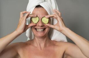 Happy mature woman having skin care spa day - People wellness lifestyle concept photo