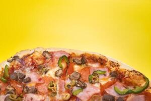 Delicious large pizza with veal and mushrooms on a yellow background photo