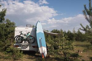 Inflatable Sup rowing boards stand near the motorhome inflated in nature during the day photo