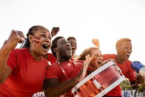 africano fútbol americano aficionados teniendo divertido aplausos su favorito equipo - fútbol deporte entretenimiento concepto foto