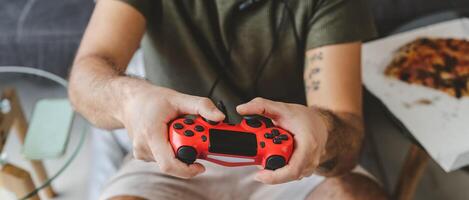 Happy man playing online video games - Young gamer having fun on new technology console - Gaming entertainment and youth millennial generation lifestyle concept photo