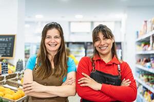 Happy women working inside supermarket photo