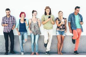 grupo de amigos acecho en su inteligente móvil Los telefonos al aire libre - joven Generacion teniendo divertido con nuevo tecnología y social red - concepto de milenario gente, tecnología y juventud estilo de vida foto