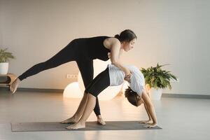 Mom and teenage daughter do gymnastics together in the fitness room. A woman and a girl train in the gym photo